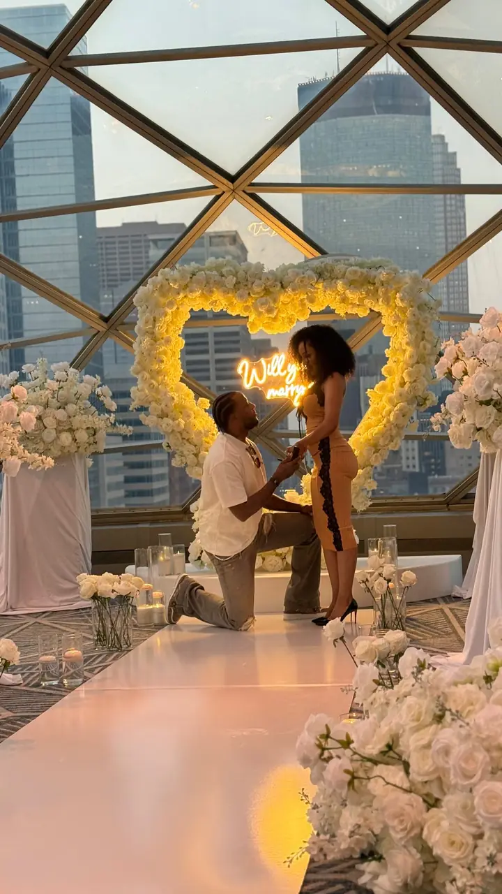 Proposal moment under a floral heart