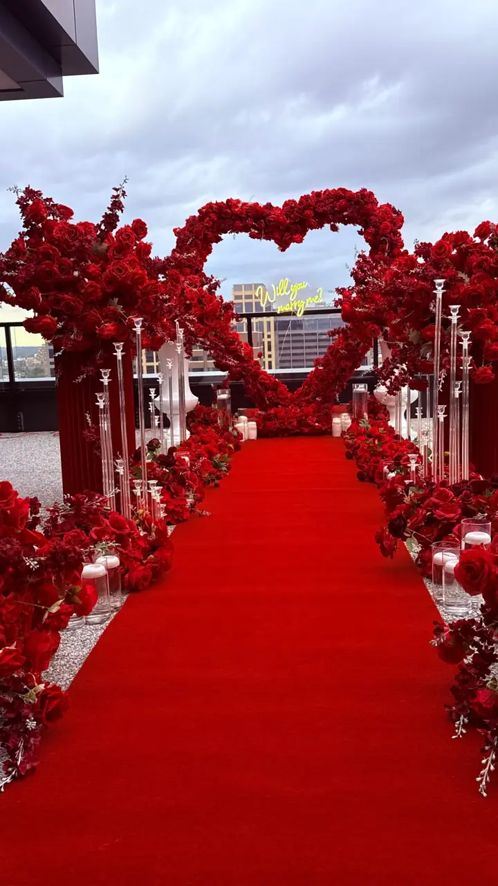 Red rose aisle and heart arch for a rooftop proposal