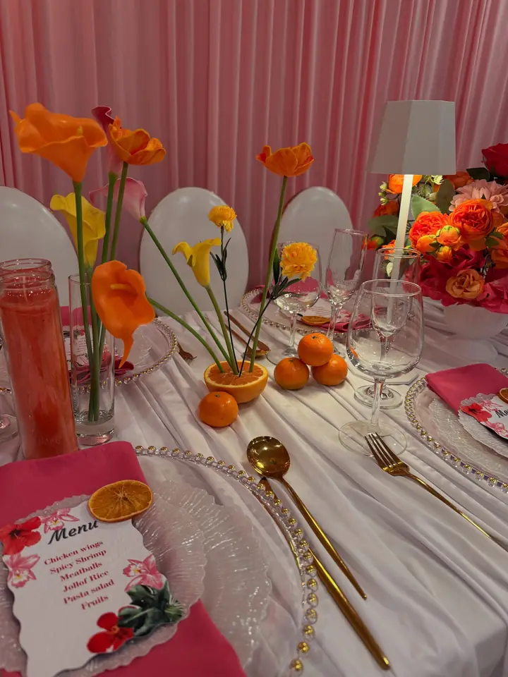 Tropical bridal shower table with orange florals and menu cards